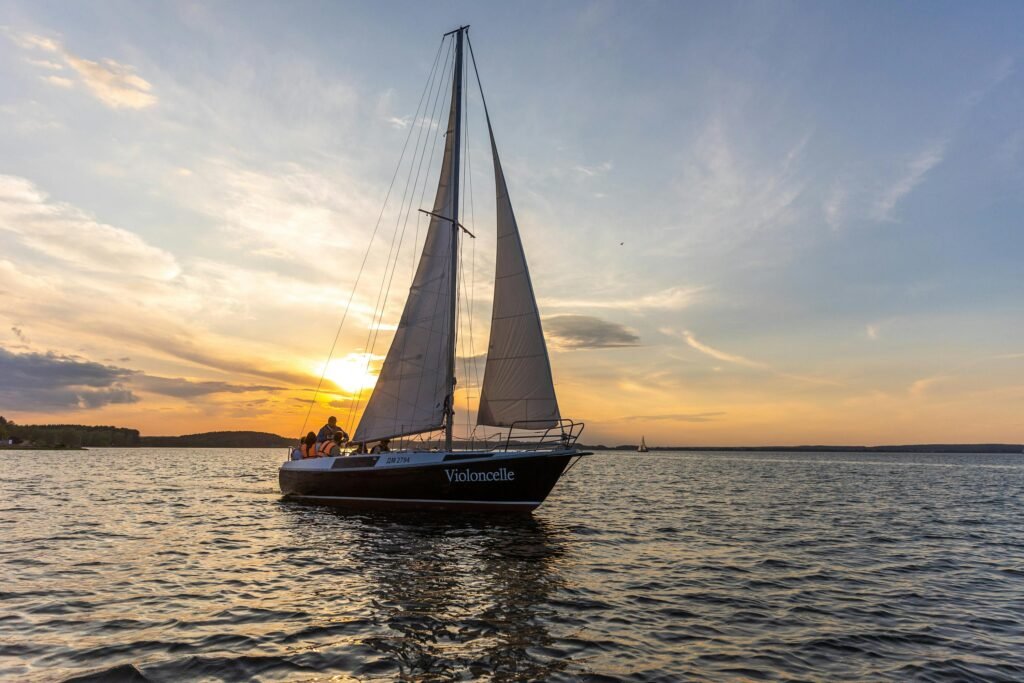 A serene yacht sailing at sunset on peaceful waters, capturing an atmospheric and romantic sea adventure.