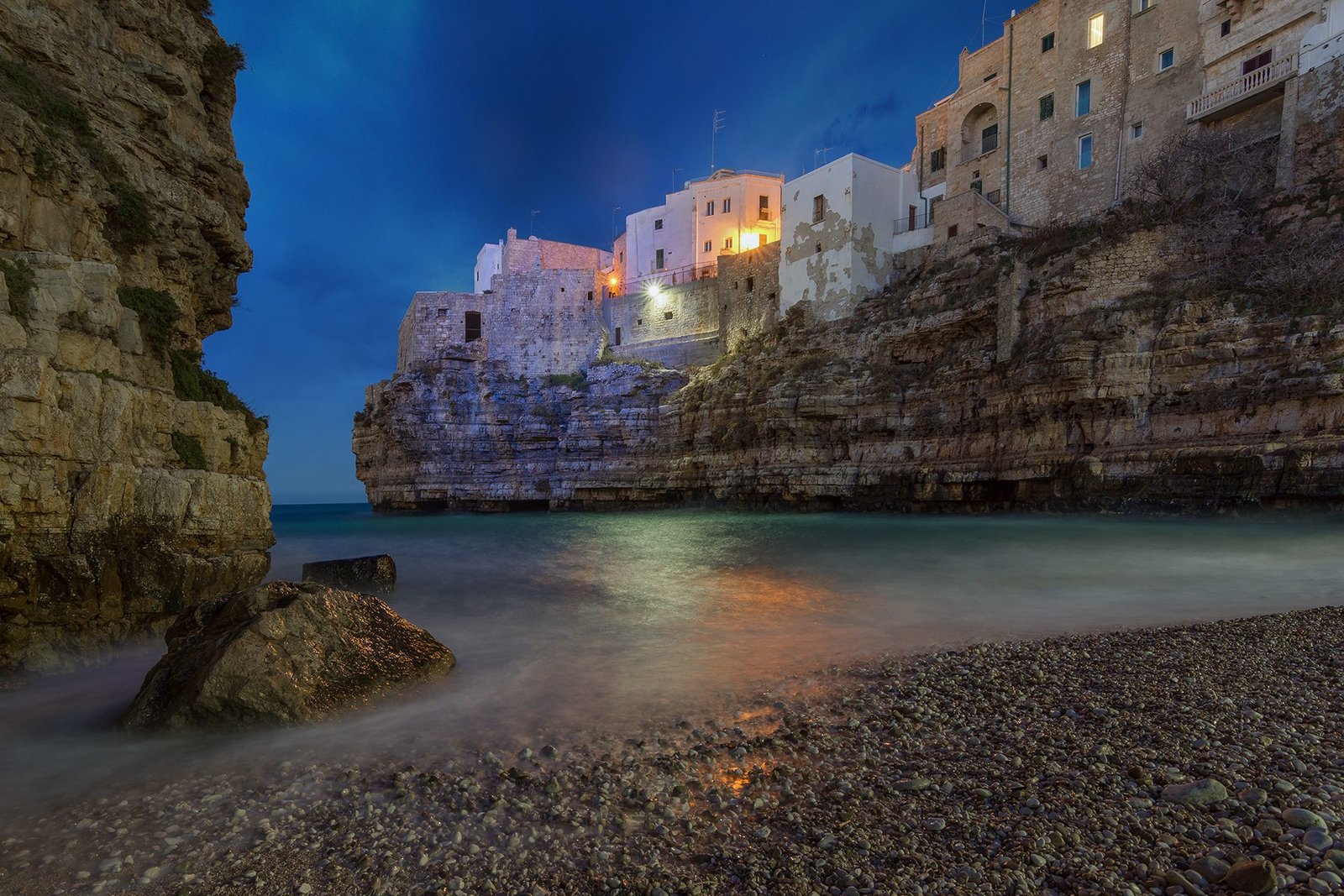 Lama Monachile cove and the old town of Polignano a Mare at blue hour