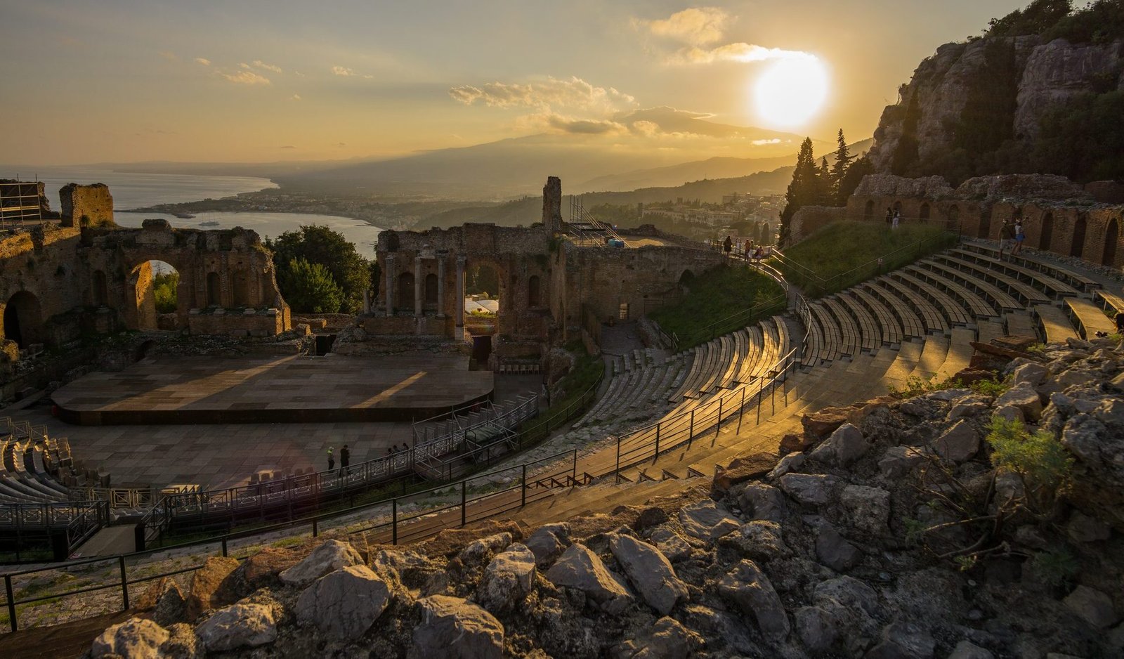 The ancient Greek theatre of Taormina at sunset with Mount Etna on the horizon