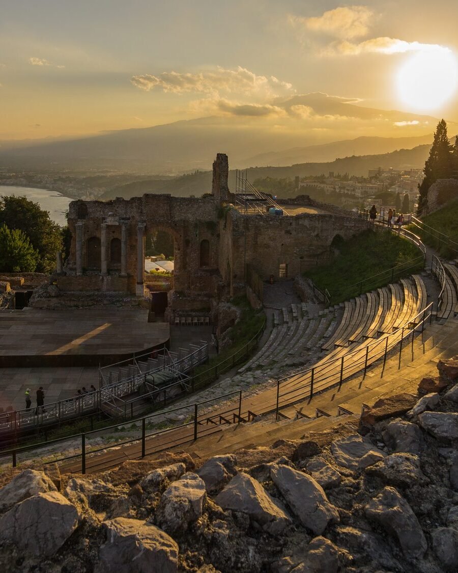 The ancient Greek theatre of Taormina at sunset with Mount Etna on the horizon